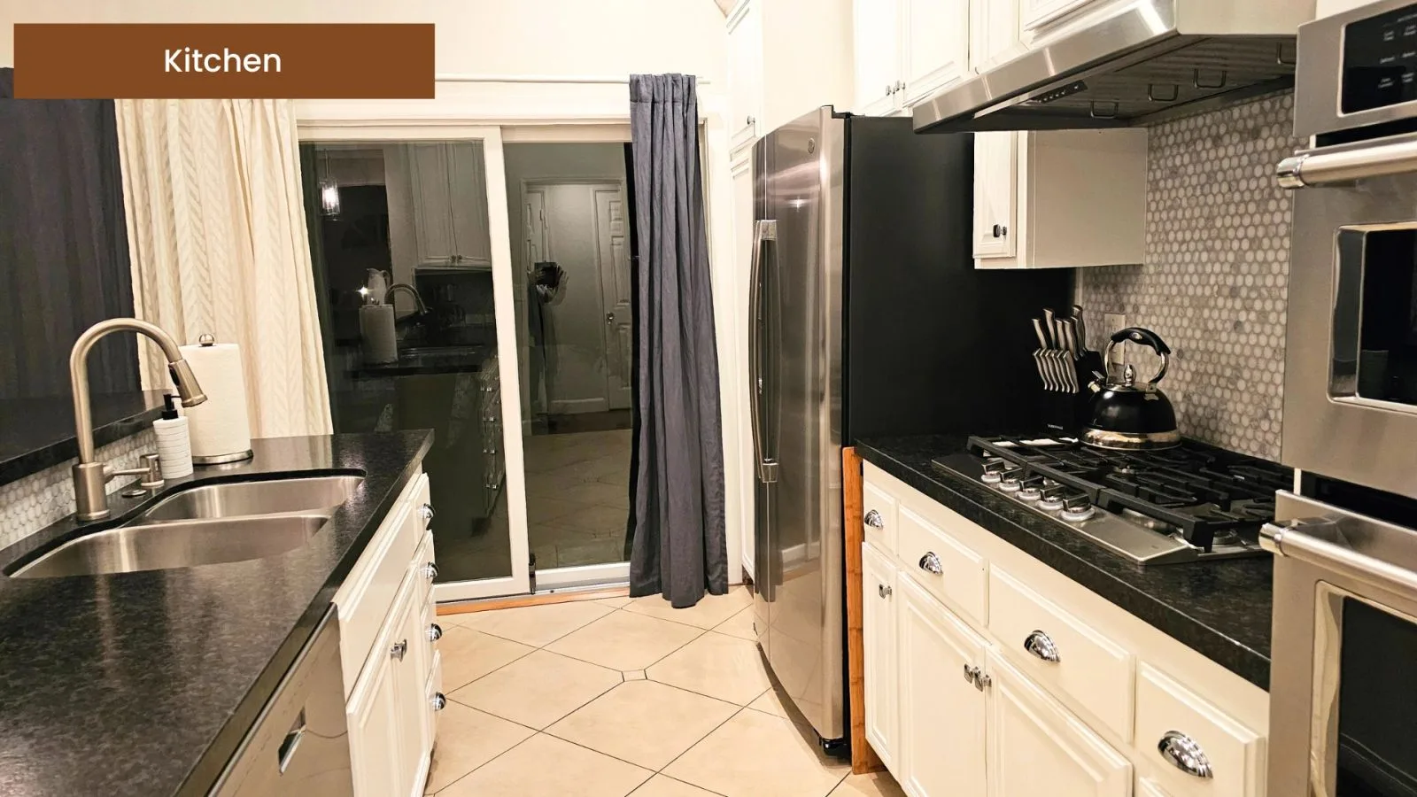 Kitchen with granite counters, stainless appliances, and a sliding door to the patio