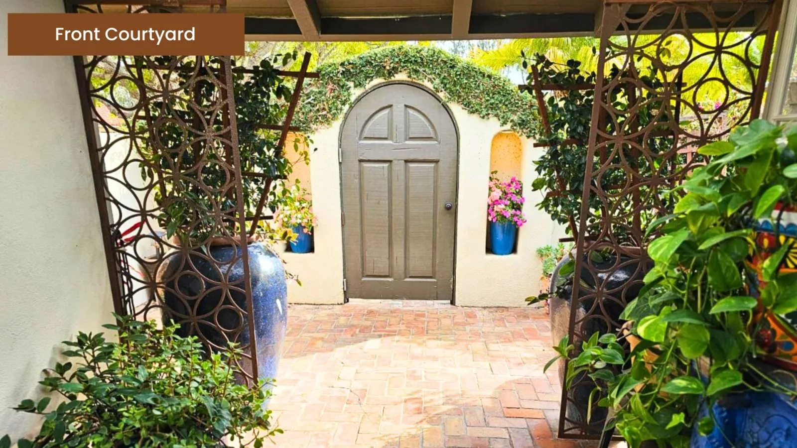 Private front courtyard with brick paving and lush planting