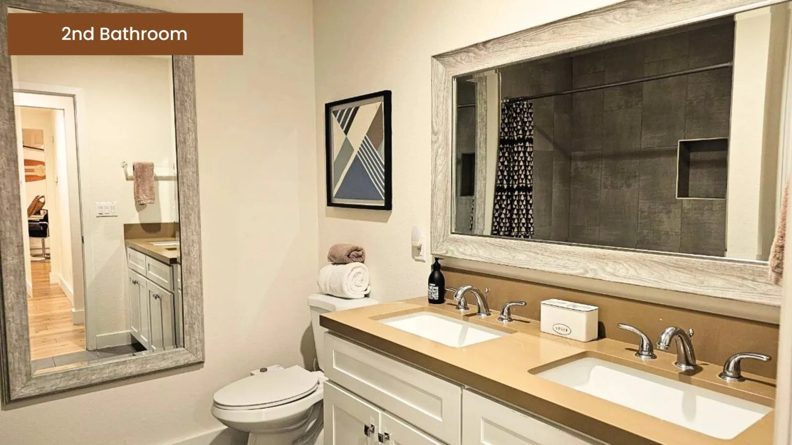 Second bathroom with dual sinks and a walk-in shower